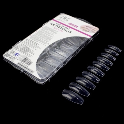 Unhas artificiais transparentes em embalagem branca e rosa sobre fundo preto