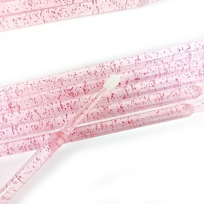 Cotonetes cor-de-rosa com pontas brancas e partículas vermelhas no cabo