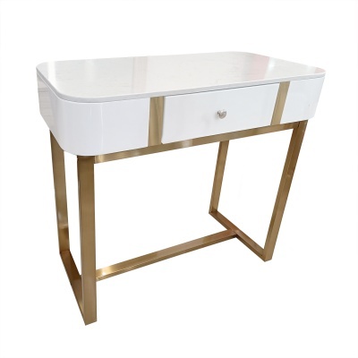 Mesa branca com estrutura metálica dourada e gavetão central