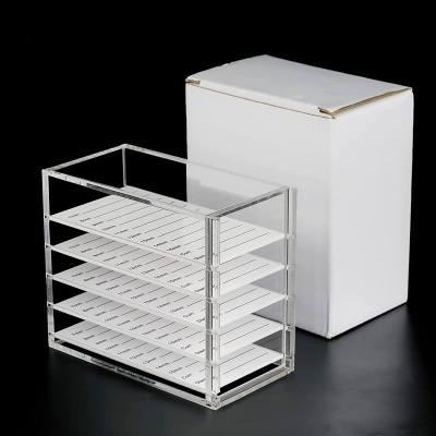 Organizador acrílico transparente com gavetas brancas e caixa branca ao lado