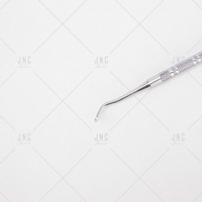 Ferramenta metálica para manicure com ponta curvada em fundo branco