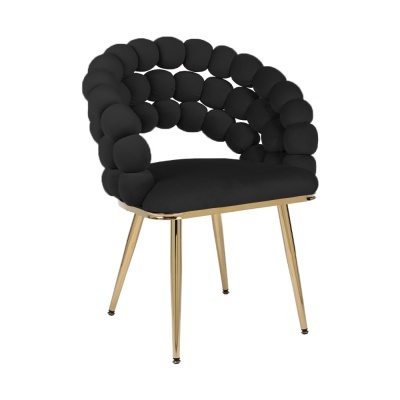 Cadeira estofada preta com pernas douradas e encosto de almofadas arredondadas