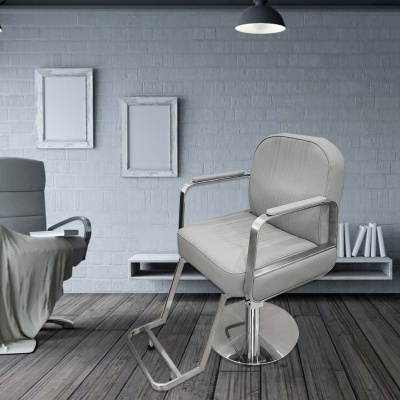 Cadeira de barbearia cinza com base metálica num ambiente com parede cinza e piso de madeira