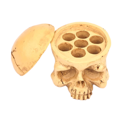 Recipiente em forma de crânio humano em cor bege com tampa e seis cavidades no interior.