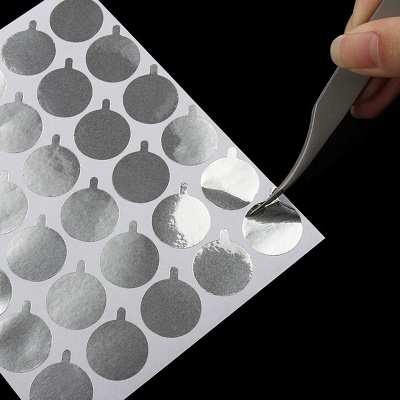 Folha com autocolantes prateados redondos a brilhar