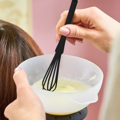Mãos mexendo mistura numa tigela branca com cabelo ao fundo