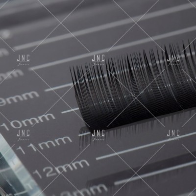 Pestanas postizas negras sobre régua milimetrada cinza