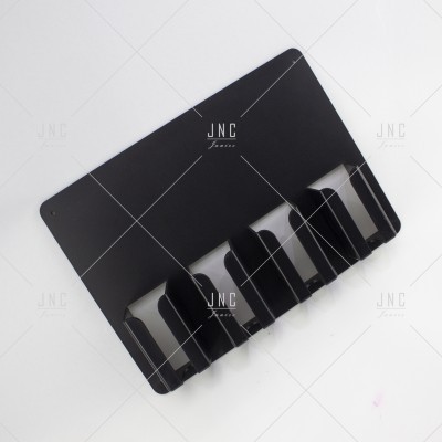 Suporte de parede preto com quatro ganchos e texto JNC