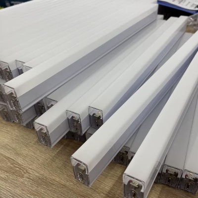 Lâmpadas fluorescentes retangulares brancas empilhadas sobre madeira clara