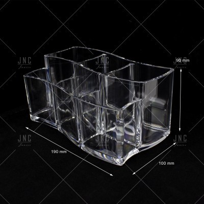 Organizador acrílico transparente com quatro compartimentos sobre fundo preto