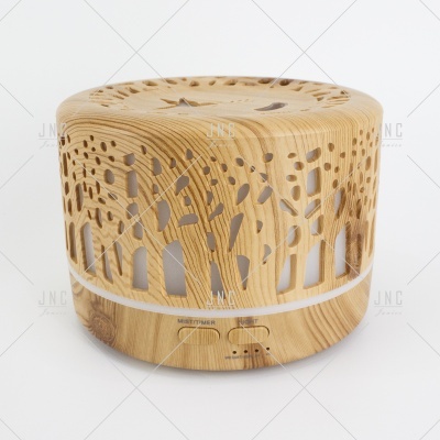 Difusor de aroma ou humidificador em madeira clara com recortes em padrão de árvores.