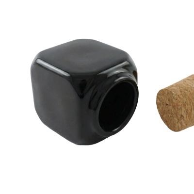 Frasco de vidro preto em forma de cubo com tampa de cortiça