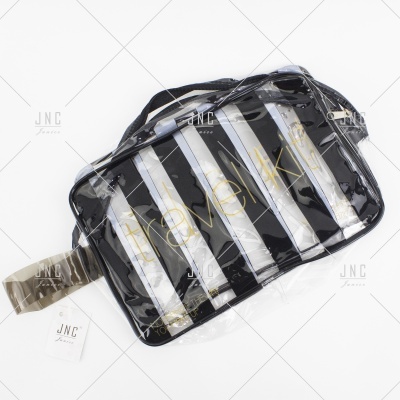 Necessaire transparente com riscas preto e branco e texto amarelo travel