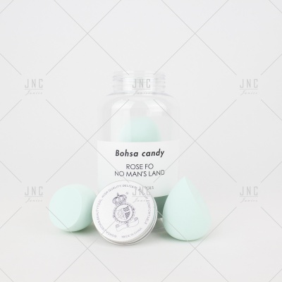 Frasco transparente com etiqueta 'Bohsa candy ROSE FO NO MAN'S LAND' e acessórios de maquilhagem azul-claro