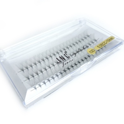 Conjunto de pestanas falsas individuais numa caixa transparente com etiqueta amarela