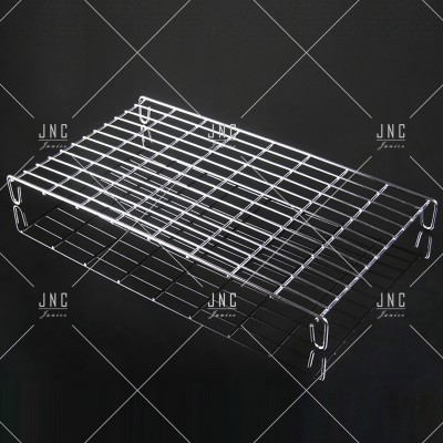 Grelha metálica retangular com pés em fundo escuro