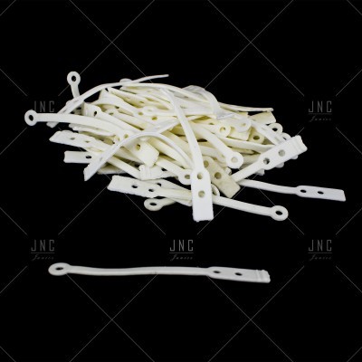 Etiquetas de plástico branco com furos, em fundo preto