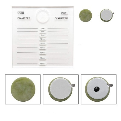 Placa com medidas e três objetos circulares verdes com parte branca e esfera preta