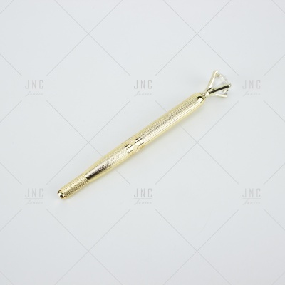 Caneta dourada com detalhe de anel