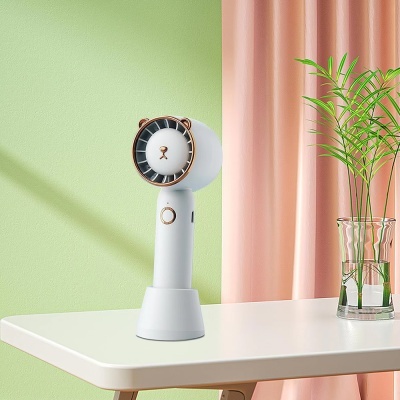 Ventoinha portátil com design de urso numa mesa com planta ao lado