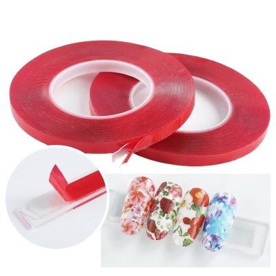 Duas fitas adesivas vermelhas transparentes em rolos com aplicação em unhas decoradas