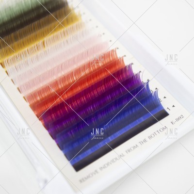 Extensões de pestanas coloridas organizadas em tiras sobre suporte branco