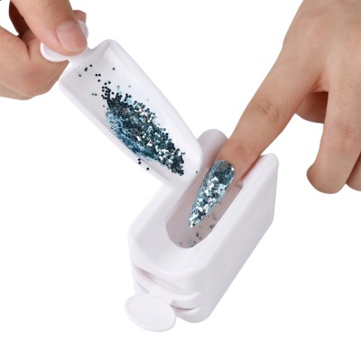 Dispositivo branco para aplicação de glitter em unhas com glitter azul prateado.