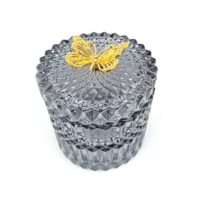 Caixa de vidro cinzento com tampa e borboleta dourada decorativa