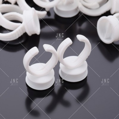 Anéis brancos de plástico com gancho sobre superfície preta