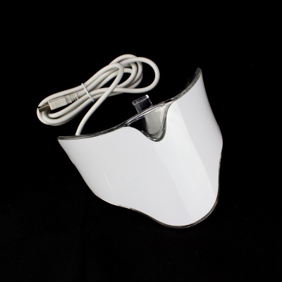 Dispositivo eletrónico branco com cabo USB sobre fundo preto