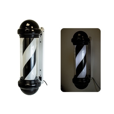 Dois sinais cilíndricos de barbearia com espiral preto e branco montados numa parede