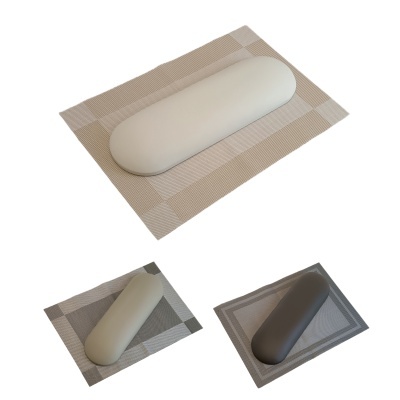 Três almofadas cilíndricas em branco, cinzento claro e cinzento escuro sobre tapetes xadrez neutros