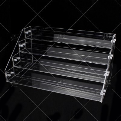 Expositor transparente de acrílico com três níveis em superfície preta
