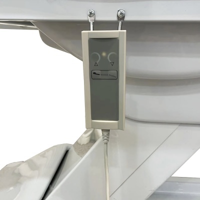 Controle remoto cinza e bege com botões para ajustar cadeira ou cama, pendurado em estrutura metálica branca