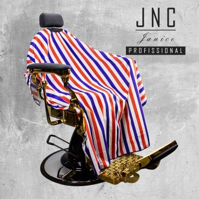 Capa de corte de cabelo listrada azul, branca e vermelha sobre cadeira de barbeiro dourada e preta