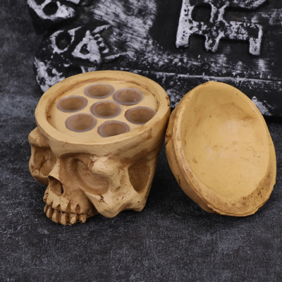 Recipiente em forma de caveira com tampa removível e orifícios para copos