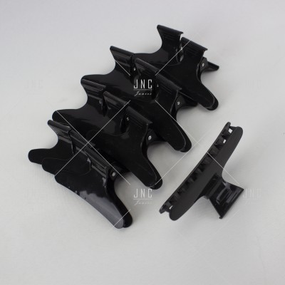 Cinco ganchos de cabelo pretos de plástico brilhante sobre fundo branco