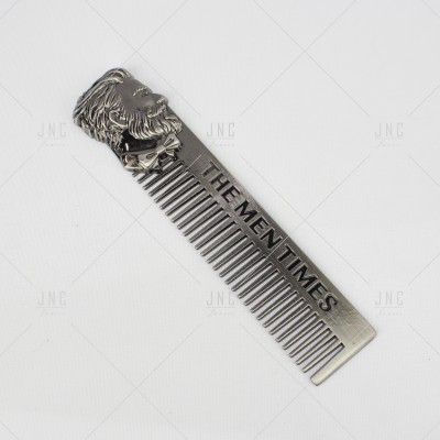 Pente metálico prateado com rosto masculino e texto THE MEN TIMES