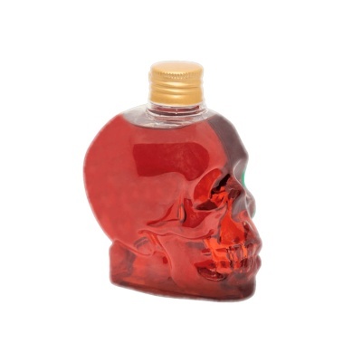 Garrafa vermelha em forma de caveira com tampa dourada