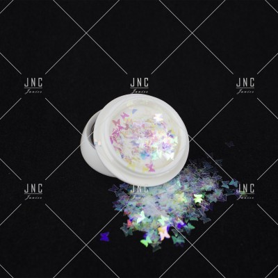 Frasco pequeno com purpurinas em forma de borboleta coloridas sobre fundo preto