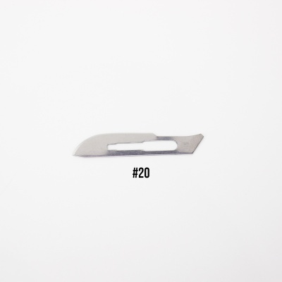 Lâmina de bisturi metálica número 20 sobre fundo branco
