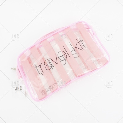 Estojo transparente com riscas rosa e branco e inscrição 'travel kit'