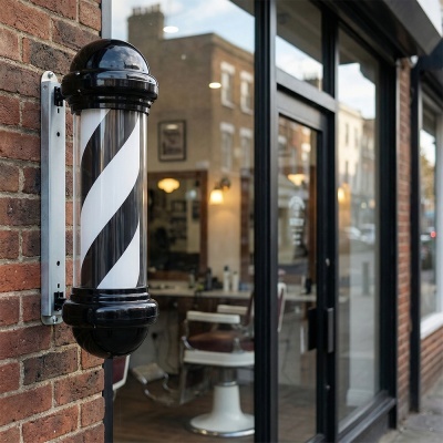 Poste de barbeiro preto e branco em parede de tijolos vermelhos junto a porta de vidro de barbearia