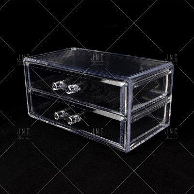 Caixa organizadora transparente de duas gavetas com puxadores claros sobre fundo preto