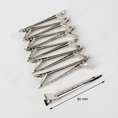 Dez pregadeiras metálicas prateadas numa superfície branca com régua indicando 90 mm
