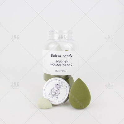 Frasco transparente com esponjas de maquilhagem verdes e brancas e etiqueta com texto