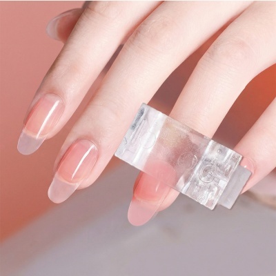 Mão com unhas naturais alongadas e anel transparente no dedo médio