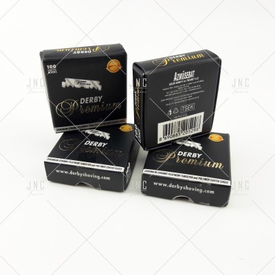 Embalagens pretas de lâminas de barbear Derby Premium com texto e detalhes dourados