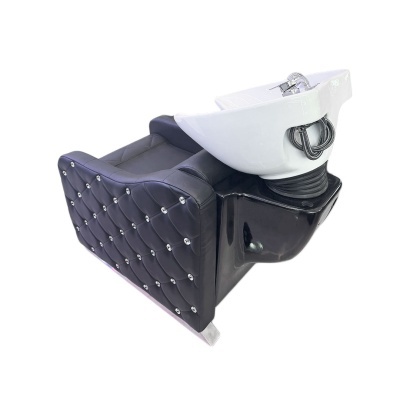 Cadeira de lavagem preta acolchoada com lava-cabeças branco e torneiras cromadas