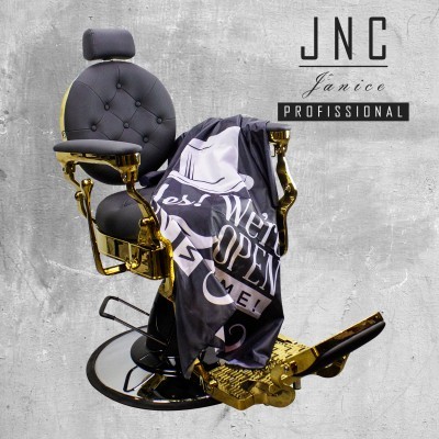 Cadeira de barbeiro preta e dourada com tapete preto e branco com texto